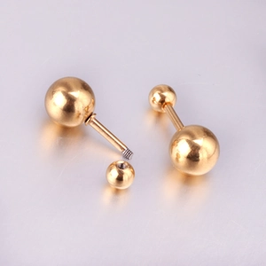 Vue macro de boucles d'oreilles boules dorées en acier avec filetage à vis