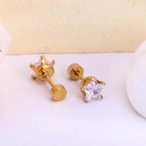Detailed macro view of gold star stud earrings with screw backs and clear cubic zirconia