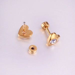 Detailed view of heart-shaped gold screw back earrings with clear round zirconia stones