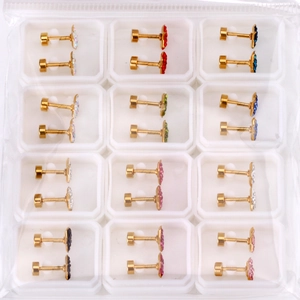 Macro shot of 12 pairs of colorful rhinestone stud earrings set in a grid display box