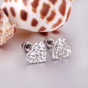 Macro shot of heart-shaped stainless steel earrings with sparkling crystals and screw back
