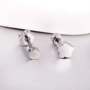 Détail de boucles d'oreilles fleur argentée avec fermoir à vis plat en acier