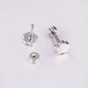 Vue macro de boucles d'oreilles fleur argentées avec finition acier poli