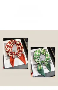 Detail of narrow silk scarf featuring classic geometric diamond patterns in dual color tones
