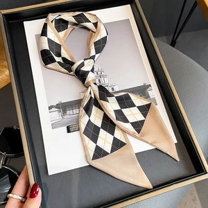 Detail of rhombic pattern skinny silk scarf tied in a bow over fashion magazine