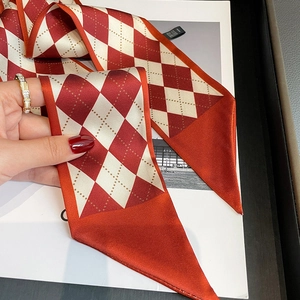 Close-up of red and white diamond pattern silk twilly scarf with smooth glossy finish