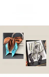 Detail of striped silk scarf with HAPPY lettering tied on a luxury leather handbag handle