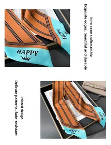 Close-up of silk neck scarf with geometric stripes and HAPPY crown print detail