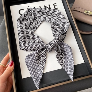 Elegant geometric black and white silk scarf with twill pattern, shown styled in a knot