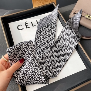 Detail of a black and white geometric silk twilly scarf displayed on a luxury tray