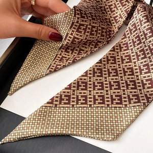 Detailed macro view of high-quality silk twilly scarf featuring geometric H-pattern design