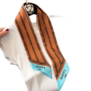 Chic orange striped twilly scarf with crown and HAPPY text shown on a decorative hook