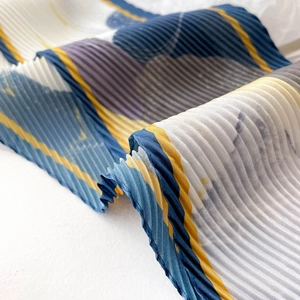 Détail d'une écharpe plissée avec motif de peinture à l'huile abstrait bleu et jaune