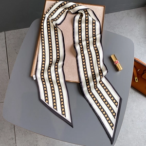 Détail d'un foulard twilly étroit et soyeux avec imprimé cœur et bords ourlés