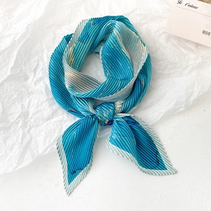 Foulard plissé en soie avec motif marbre bleu et touches dorées sur fond blanc