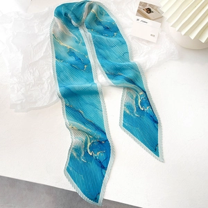 Détail macro d'une écharpe longue plissée avec un motif de marbre bleu et doré chic