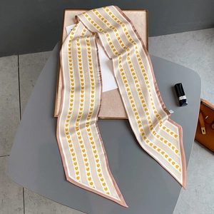 Détail d'un foulard étroit en satin à motif cœur avec des accessoires de luxe élégants