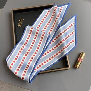 Vue détaillée d'un foulard étroit à rayures bleu clair avec motif cœur rouge sur plateau