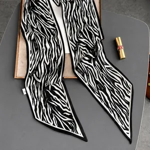 Detalle de bufanda de seda con estampado de cebra en blanco y negro y costuras finas