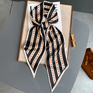 Écharpe à rayures noir et blanc avec cœurs orange sur un plateau de luxe