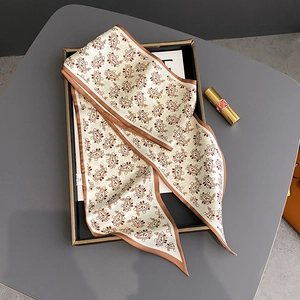 Elegant beige paisley print skinny silk scarf displayed in a decorative black frame