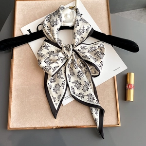 Elegant black and white paisley silk scarf with white camellia flower on velvet hanger