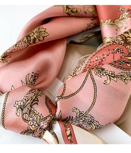 Close-up of vintage carriage pattern silk scarf with golden chain floral design