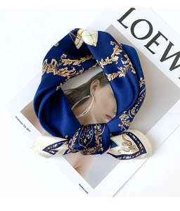Close-up of silk scarf with golden Baroque patterns on a royal blue background