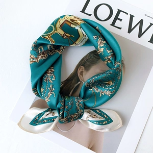 Teal silk scarf with vintage carriage pattern and baroque gold accents on white surface