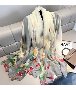 Close-up of elegant lotus print scarf with gradient tones on luxury leather background