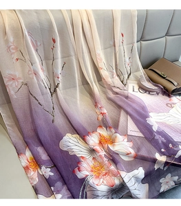 Detail of elegant lotus print silk scarf with gradient color on a soft sofa