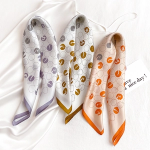 Three silk twilly scarves with polka dot patterns and contrast edging in a flat lay view