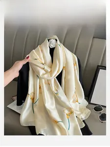 Detail of cream silk scarf featuring orange and green calla lily floral patterns