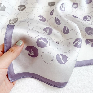 Detail of silk scarf with purple dots and hand-stitched rolled edges showing texture