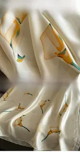 Detail showing high-quality overlock stitching and vibrant floral print on silk scarf