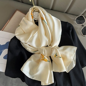 Elegant champagne silk scarf with yellow floral pattern and camellia brooch on black top