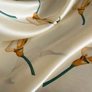 Close-up of elegant faux silk scarf featuring calla lily floral print and soft sheen