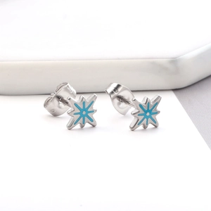 Detailed view of silver starfish earrings with sky blue enamel on a marble surface