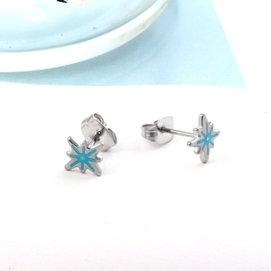 Macro detail of star-shaped stud earring with light blue enamel and stainless steel finish