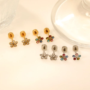 Minimalistische Blumenohrstecker mit Kristallen in Gold und Silber auf weißem Grund