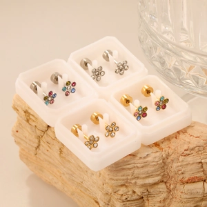 Ohrstecker-Set mit Blumenmotiven und Kristallen auf einem Naturstein-Display