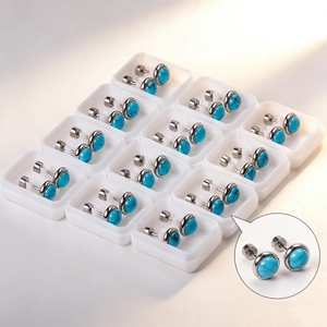 Twelve pairs of round blue turquoise stud earrings in silver settings and packaging