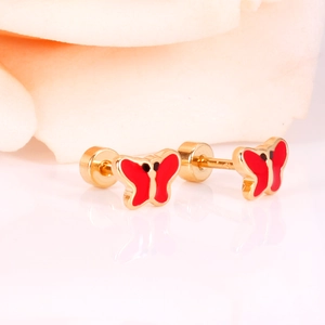 Macro shot of gold butterfly earrings with red enamel wings and secure screw backs