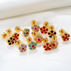 Gros plan de boucles d'oreilles fleurs en émail coloré avec fermoirs à vis sur soie