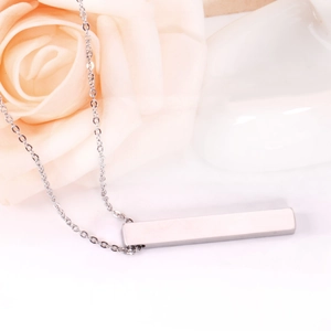 Detailed view of silver bar pendant necklace with mirror polish on a rose background