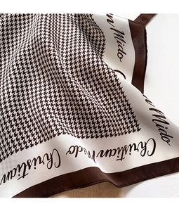 Close-up of silk houndstooth scarf showing soft folds and elegant Christian Mido printing