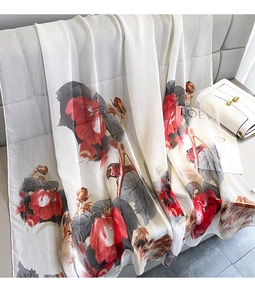 Detail of elegant ivory sheer scarf featuring red floral patterns and light silk texture