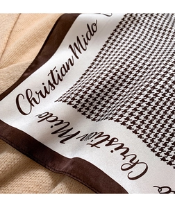 Detail of silk houndstooth scarf with elegant pattern and Christian Mido logo script