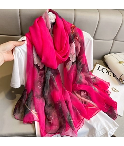 Macro detail of elegant floral silk shawl with artistic ink patterns and vibrant rose pink color