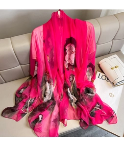 Close-up of elegant floral silk scarf draped on a sofa with premium glossy texture